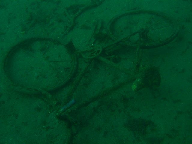 Bicycle in Sand Next to USS Indra